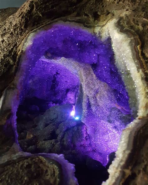 The Inside Of A Rock With A Purple Light In It