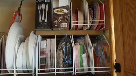 An Organized Kitchen Cabinet With Dishes And Utensils