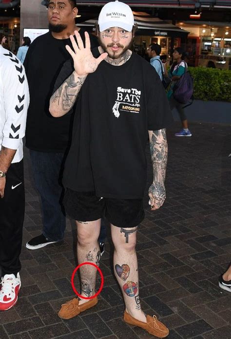 A Man With Tattoos On His Arms And Legs Standing In Front Of A Crowd At