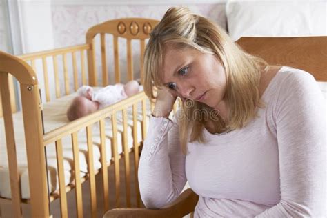 Mother In Nursery Suffering From Post Natal Depression Stock Photo