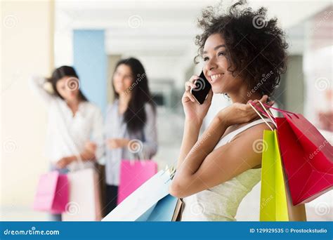 Mulher Afro Americano Entusiasmado Que Fala No Telefone Celular Na Alameda Imagem De Stock