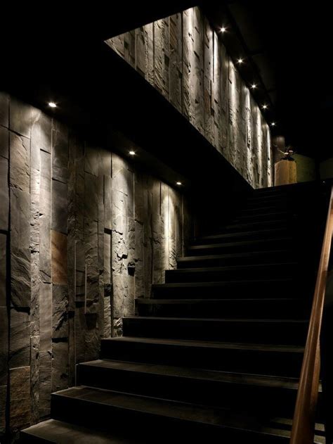 The Stairs Are Lit Up By Lights In This Dark Room With Stone Walls And