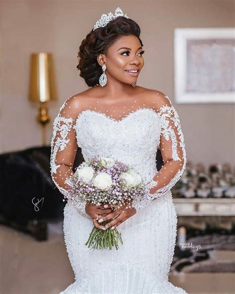 A Woman In A White Wedding Dress Holding A Bouquet And Smiling At The