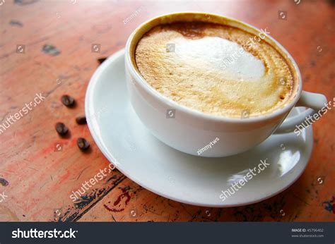 Cup Of Frothy Cappuccino Coffee With Coffee Beans Stock Photo 45796402