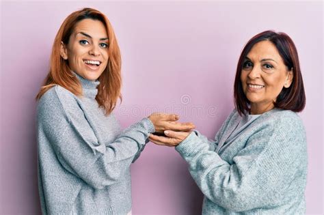 Latin Mother And Daughter Wearing Casual Clothes Pointing Aside With Hands Open Palms Showing