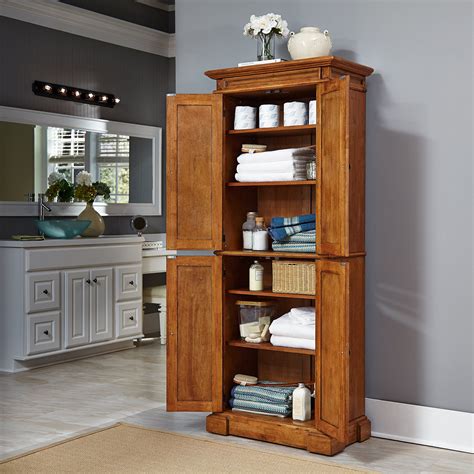 If i was facing down an oak kitchen that i wanted to live with, in harmony, for a bit of time, here's what i would do in one weekend: Home Styles 500469 Americana Pantry Storage Cabinet ...