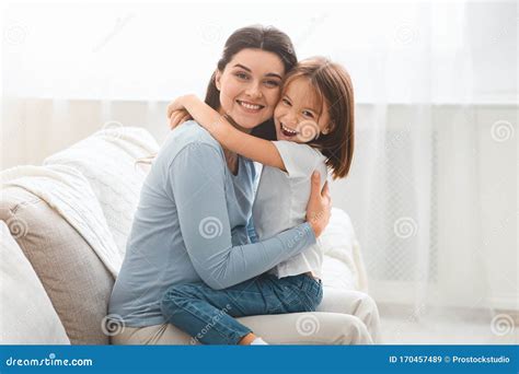 Little Daughter And Young Mother Hugging Each Other At Home Stock Image