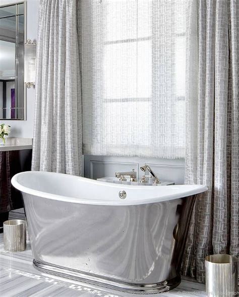 A luxurious white marble bathroom with a large window with curtains, a tub clad with marble and a shower space. Can you picture yourself here? Image via Brandon Barré ...