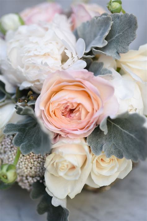 summertime bridal bouquet featuring mix of pale toned roses peonies pale ivory roses and