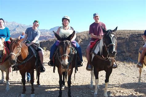 Four People Are Riding Horses In The Desert