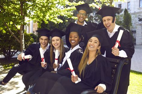 Group Of Laughing Multicultural People In Graduation Gowns And Caps