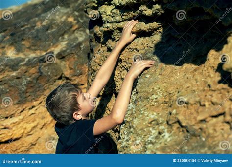 A Boy Climbs A Cliff On A Steep Cliff Stock Photo Image Of Extreme
