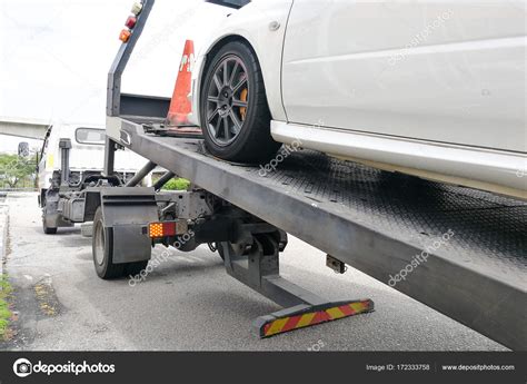 Car Towed Onto Flatbed Tow Truck With Hook And Chain Stock Photo By
