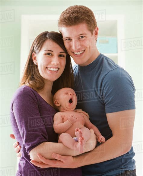 Caucasian Mother And Father Holding Baby Girl Stock Photo Dissolve