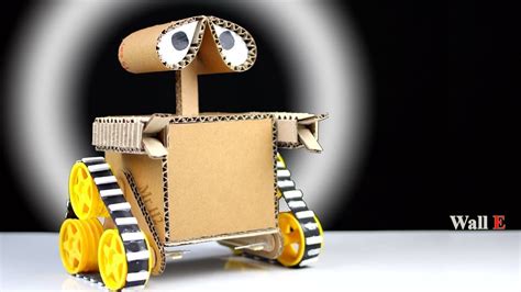 A Robot Made Out Of Cardboard With Yellow Wheels And Eyes On Its Head