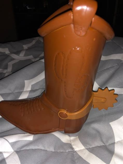 A Brown Cowboy Boot Sitting On Top Of A Bed