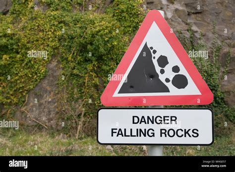 Old Dented Danger Falling Rocks Sign Red Triangle With Black On White