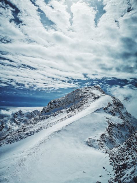 Snow Covered Mountain Under Cloudy Sky · Free Stock Photo