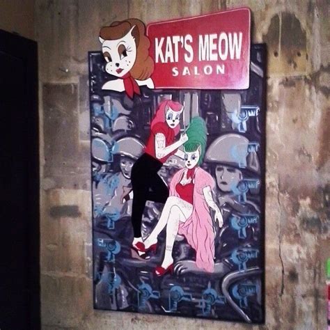 A Painting On The Side Of A Wall With A Woman And Cats Meow Sign