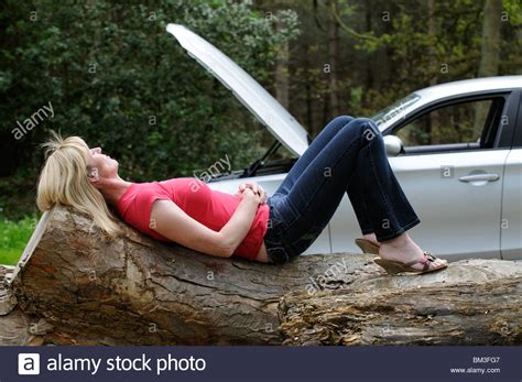 Roadside Breakdown Woman Motorist Relaxing On A Log On A Country Lane And Wait For A Breakdown