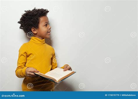 Curious Black Child Boy Reading A Book On White Background Stock Image