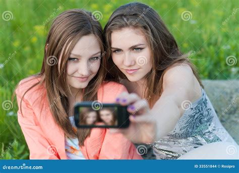 Twee Gelukkige Tieners Die Beeld Van Zich Met Mobiele Telefoon Nemen Stock Foto Image Of Gras