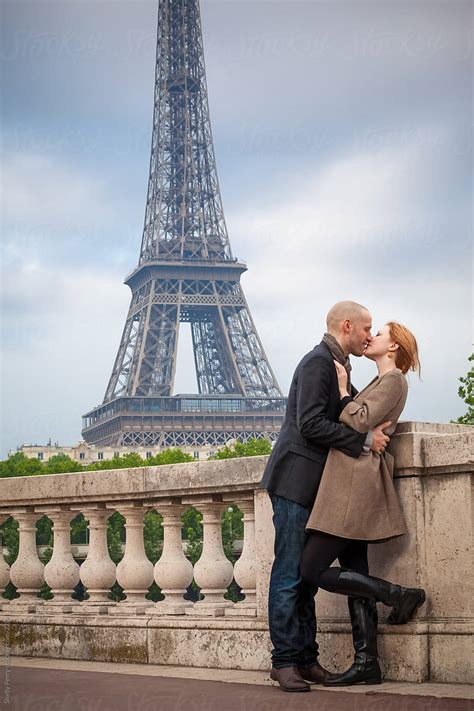 Romantic Couple In Paris Kissing Eiffel Tower In The Background By