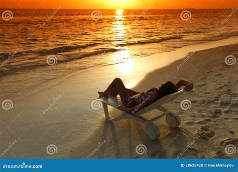 Woman In Chaise Lounge Relaxing On Beach Royalty Free Stock Photos