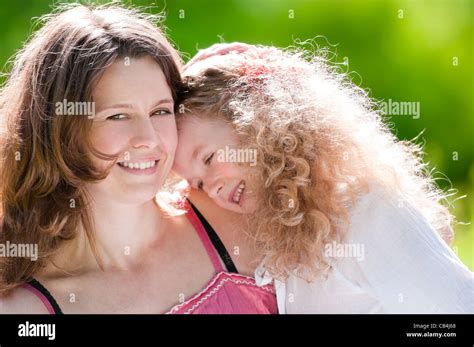 Beautiful And Happy Young Mother Hugging Her Daughter Both Smiling
