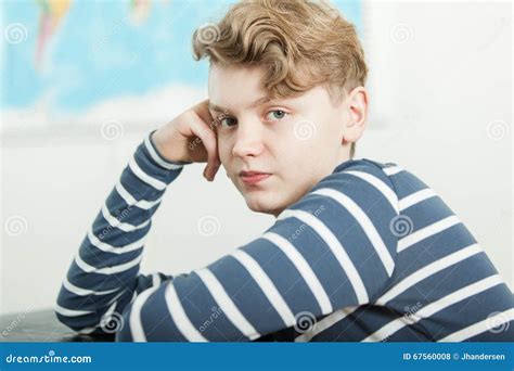 Boy Sitting At Desk With Head Resting On Hand Stock Photo Image Of