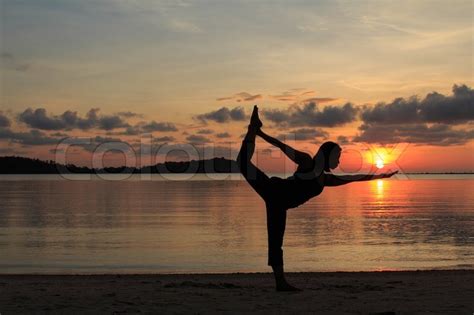 Silhouette Of A Beautiful Yoga Girl At Sunrise On The