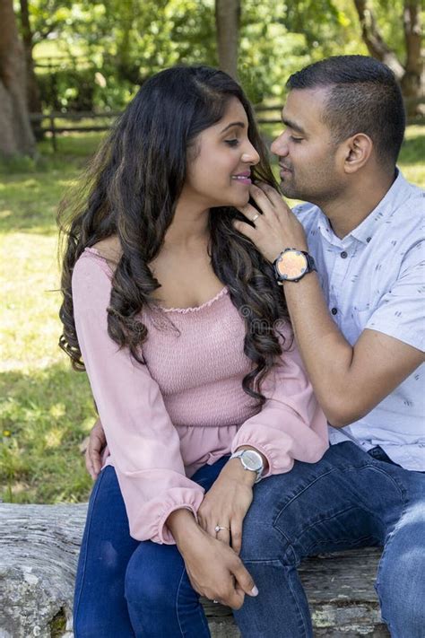 Asian Indian Married Couple Being Romantic In A Park Like Setting Stock