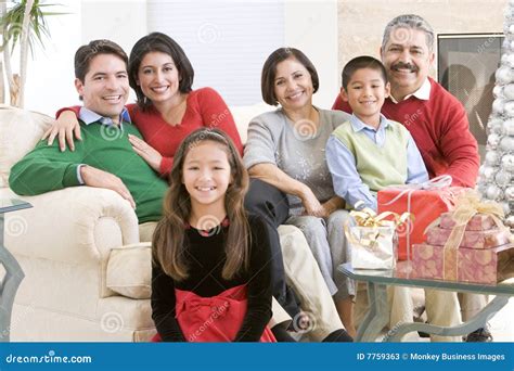 Familia Que Se Sienta Alrededor De Una Mesa De Centro Imagen De Archivo