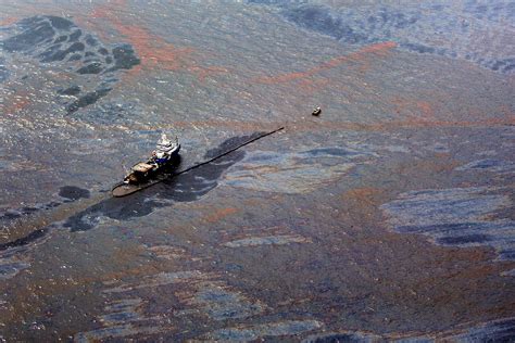 Oil Floats On The Surface Of The Gulf Of Mexico Around A Work Boat At