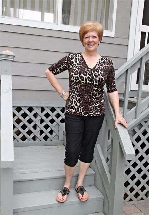 A Woman Standing On The Steps Of A House With Her Hands On Her Hips And