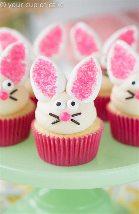 Some Cupcakes With Bunny Ears On Them Are Sitting On A Green Plate And