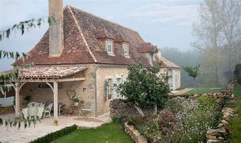 The House Is Surrounded By Greenery And Stone Walls As Well As An