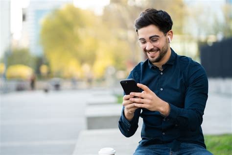 Free Photo Portrait Of Young Man Using A Mobile Phone While Standing