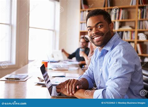 Businessman Using Laptop At Desk In Busy Office Stock Image Image Of