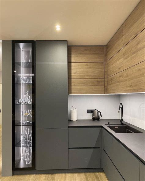 A Modern Kitchen With Wooden Cabinets And Stainless Steel Counter Tops Along With Glass Shelves