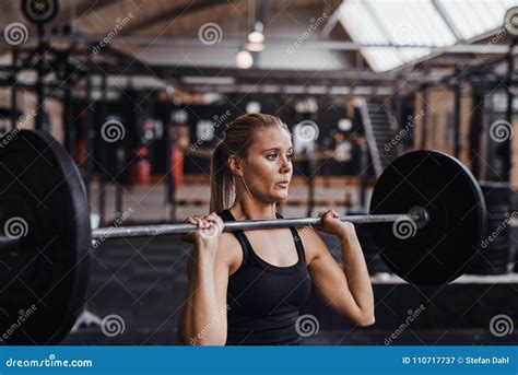 Young Woman Lifting Barbells Over Her Head In A Gym Stock Image Image