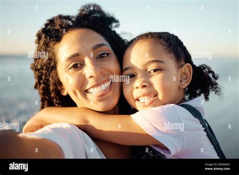 Beach selfie with happy mother, child hugging mom and summer travel