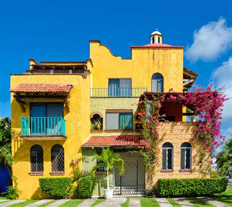 A Large Yellow House With Many Windows And Balconies