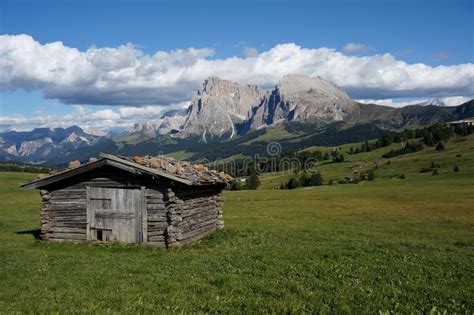 Wooden Cabin On Large Alp And Dolomite Mountains In Background Stock
