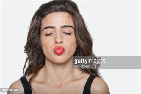 Beautiful Woman Puckering Lips With Eyes Closed Over Gray Background