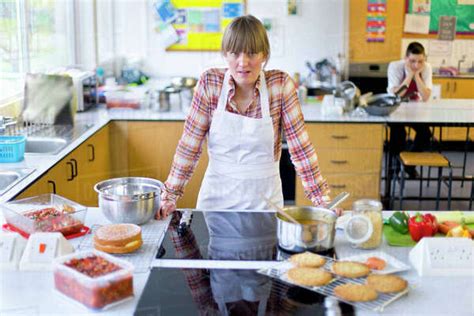 Portrait Frustrated Home Economics Teacher Cooking In Kitchen Classroom