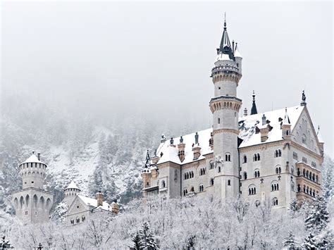 An Old Castle In The Middle Of Winter With Snow On The Ground And Trees