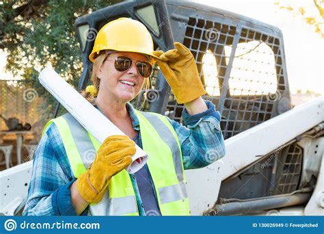 happy female construction worker holding blueprints stock image image of girl building 130026949