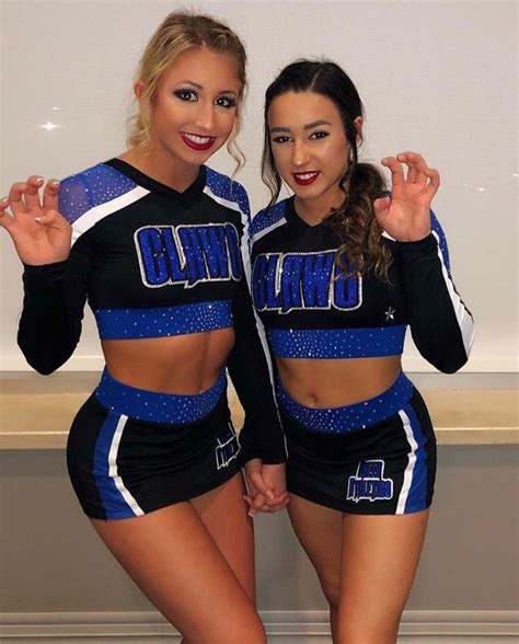 Two Cheerleaders Are Posing For The Camera