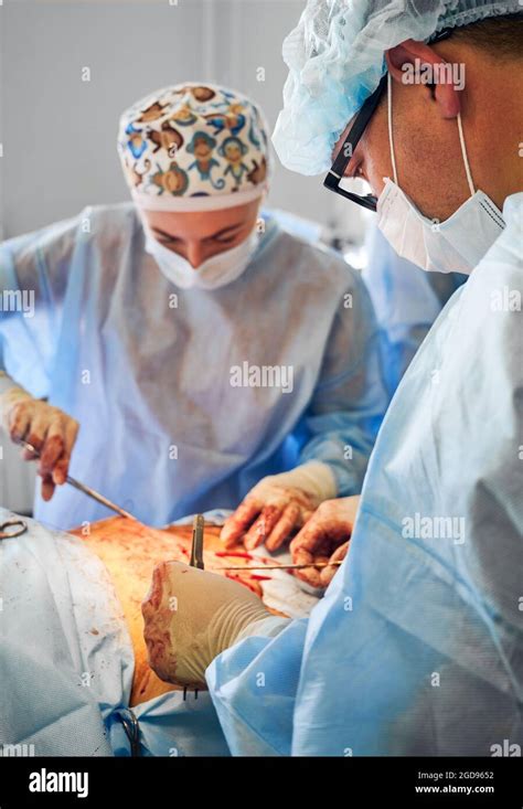 Doctors Performing Abdominoplasty Surgery In Clinic Focus On Male